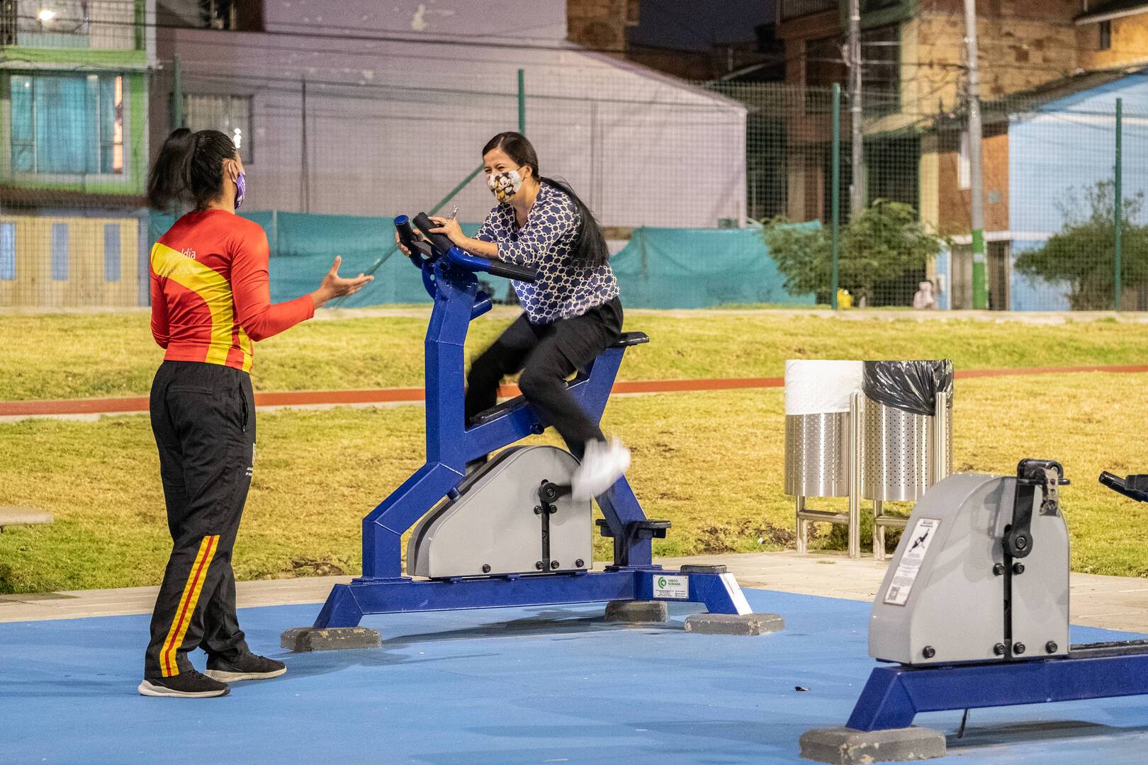 Instructora guiando a una usuaria de un gimnasio al aire libre