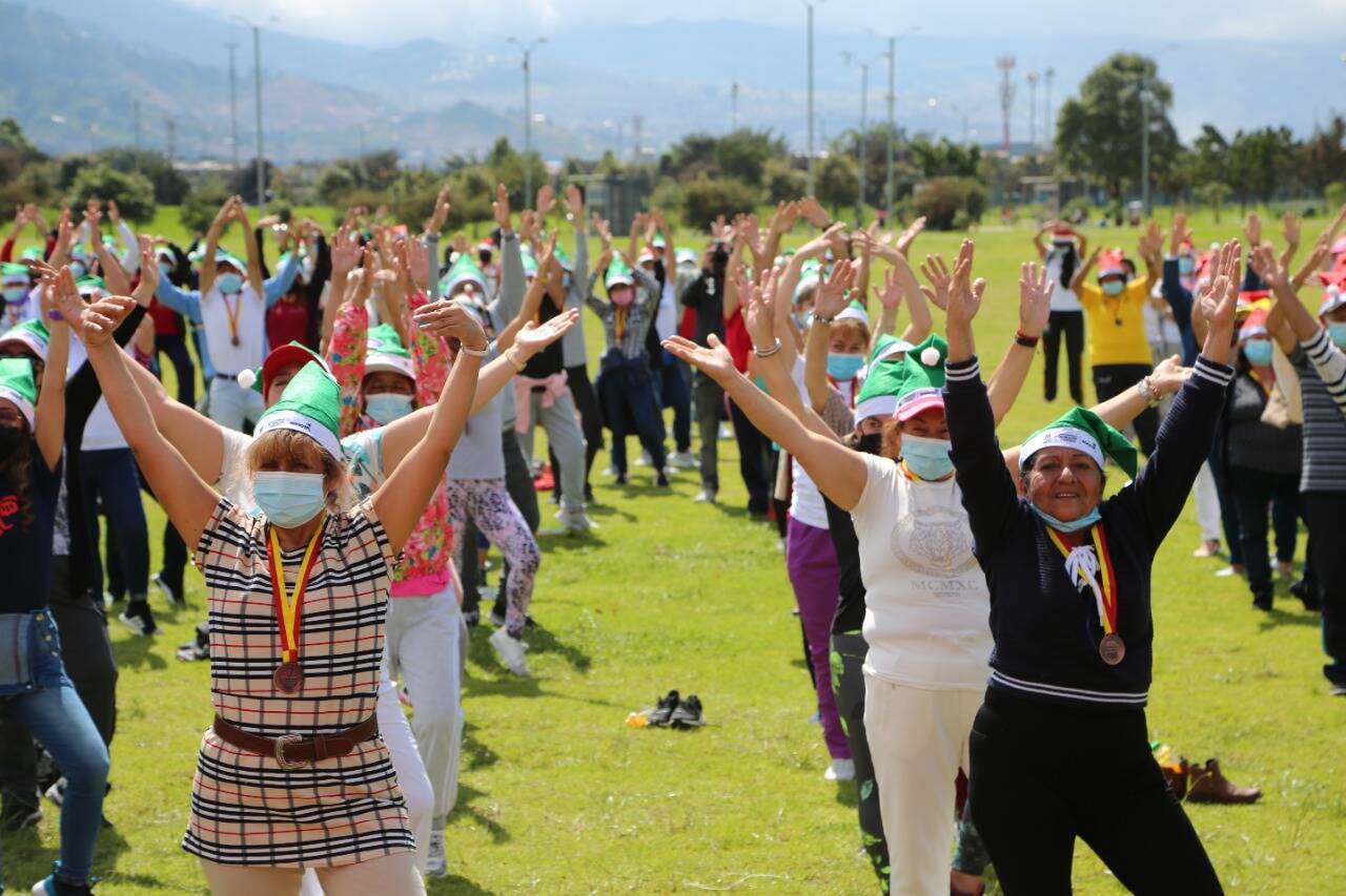 Varias personas mayores con gorros de Navidad en un parque