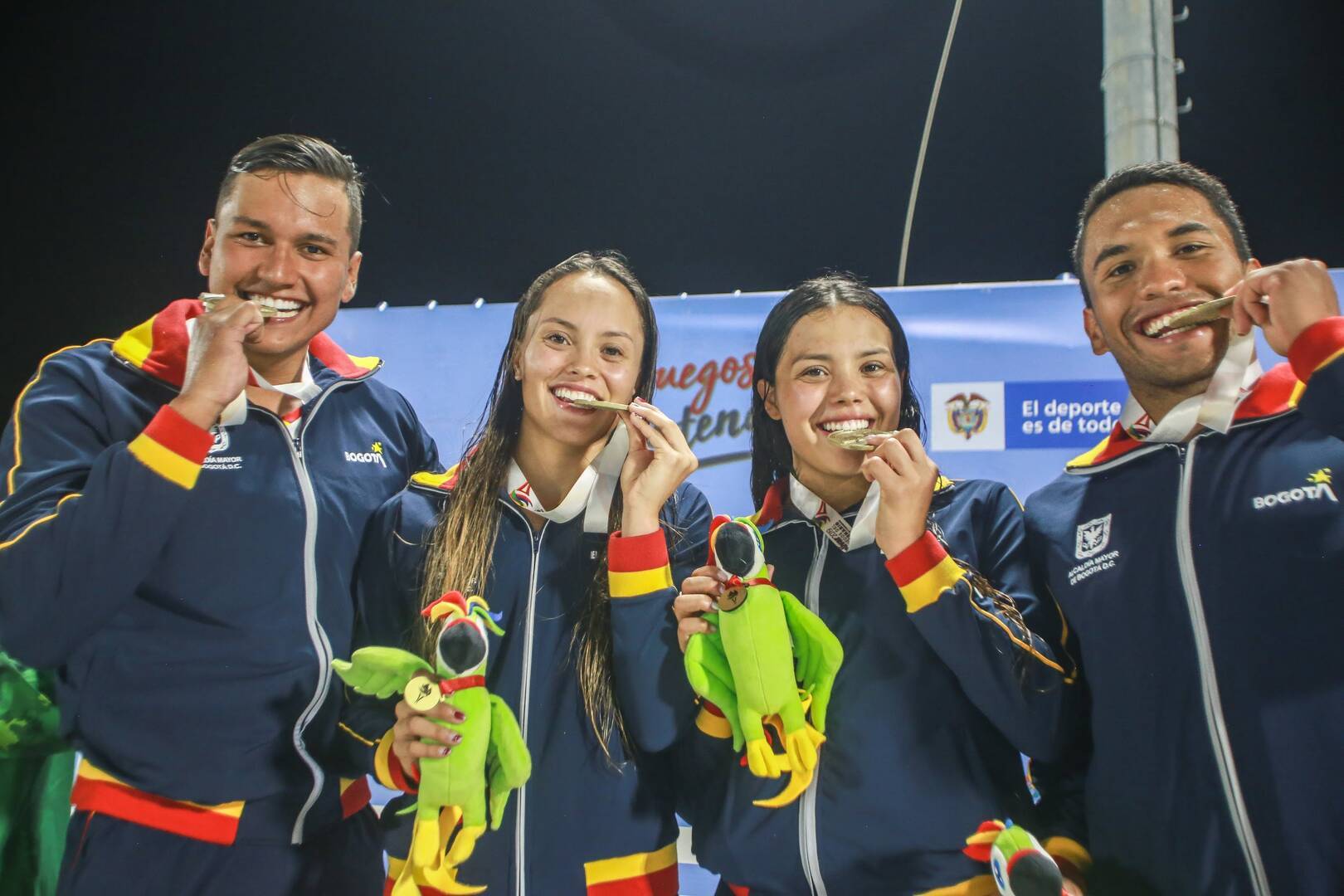 Camila y Paula Aguirre, Andrés Torres y Vladimir Tovar mordiendo medalla