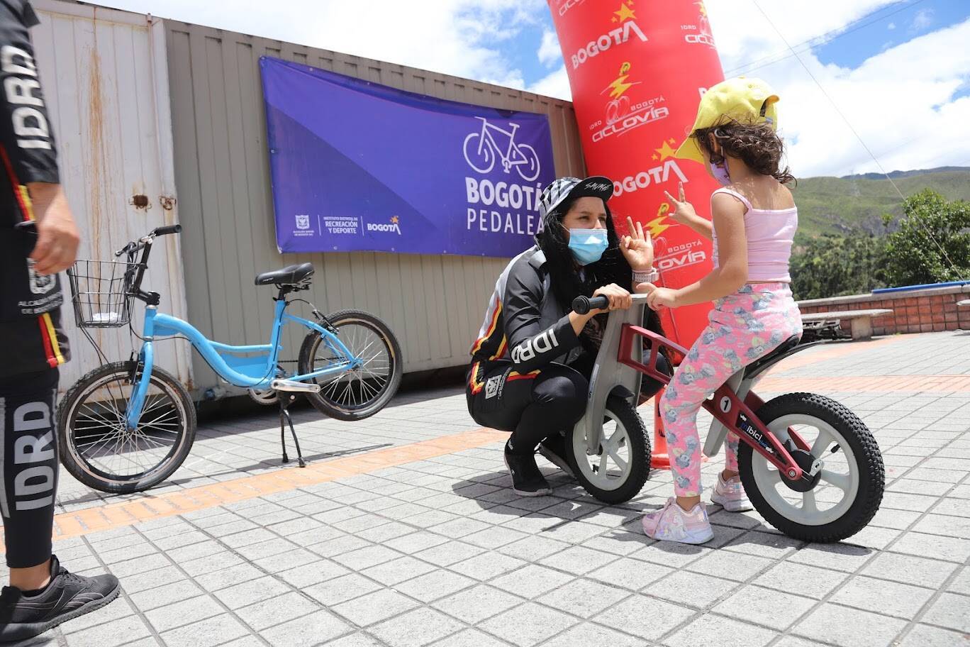 Profesora del IDRD dando instrucciones a niña en bicicleta