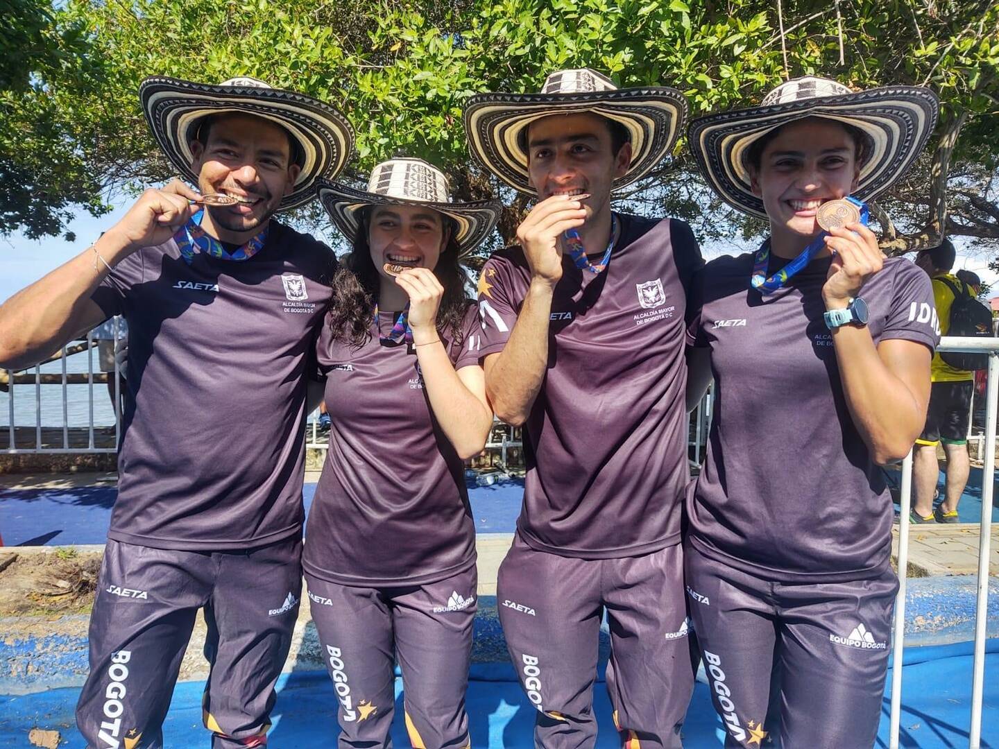 deportistas mordiendo medallas
