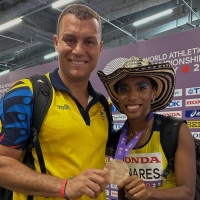 El entrenador Martín Suárez y su pupila, Natalia Linares, con su histórica medalla de bronce en el salto largo del Mundial de Atletismo en Tokio. Foto IDRD.