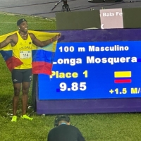 Ronal Longa posa orgulloso junto al tablero electrónico que confirmó su récord suramericano en los 100 metros lanos. Foto Sebastián Lasquera / Consudatle.