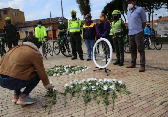 personas dejando flores en el suelo