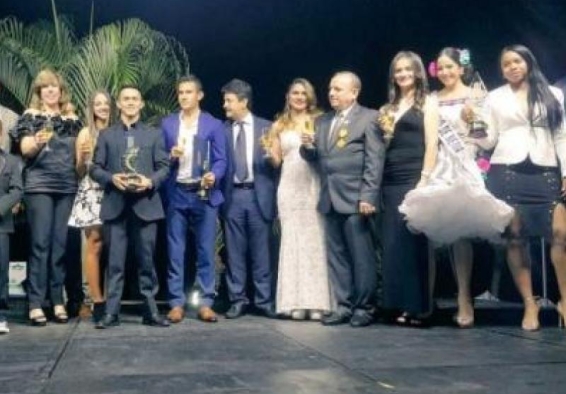 Deportistas sostienen trofeos en ceremonia