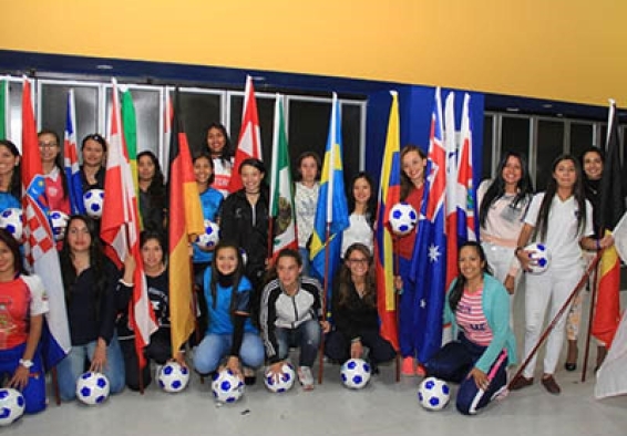 Deportistas sostienen banderas y balones de fútbol