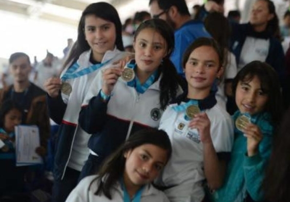Niñas deportistas sostienen medalla