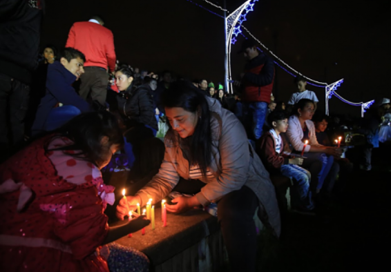 personas prendiendo velitas 