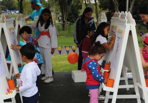 Niños pintan lienzos en parque