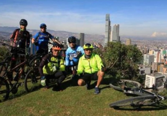 Ciclistas en un mirador y en el fondo la ciudad
