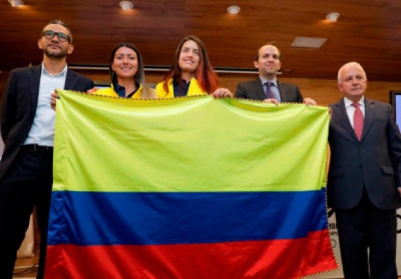 Deportistas y representantes de la delegación sostienen bandera