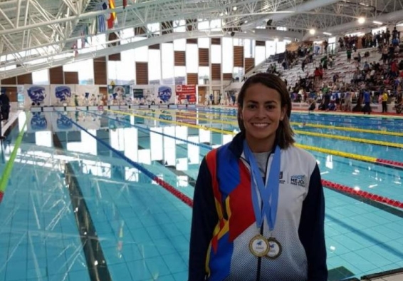 Deportista de natación con aletas posa con su medalla