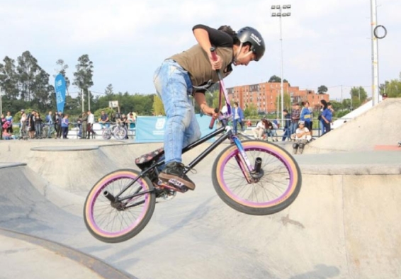 Mujer monta bicicleta en pista de skate