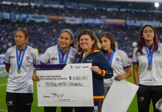 La directora del IDRD Blanca Durán entregando un cheque a una de las jugadoras