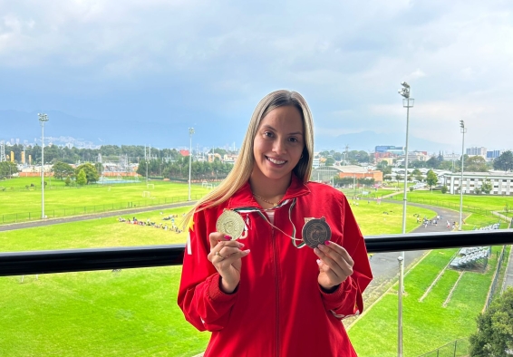 Paula Aguirre mostrando dos medallas