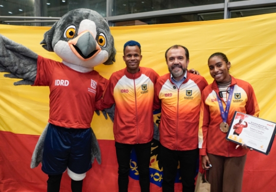 Carlos Sanmartín (izq.) con el director del IDRD, Daniel García Cañón, y Natalia Linares, a su llegada a Bogotá. Con ellos, Xue, una de las mascotas de la escuadra capitalina. Foto IDRD.