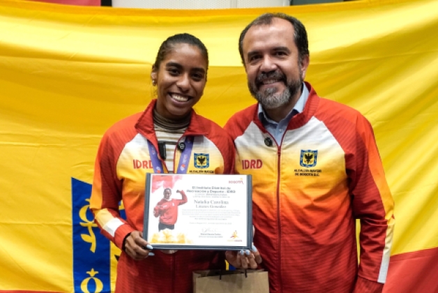 La medallista mundial de salto largo, Natalia Linares, con el director del IDRD, Daniel García Cañón, quien le hizo entrega de una distinción por el logro alcanzado en Tokio 2025. Foto IDRD.