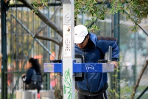 Hombre usando las maquinas de un gimnasio en un parque