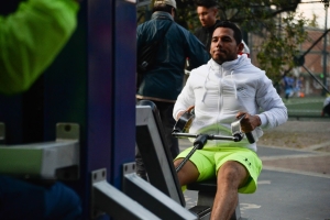 Hombres usando las maquinas de un gimnasio en un parque