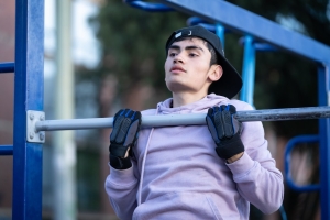 Hombre usando las maquinas de un gimnasio en un parque