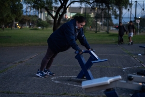 Mujer usando las maquinas de un gimnasio en un parque