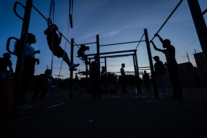 Personas usando las maquinas de un gimnasio en un parque