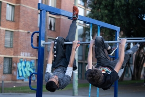 2 hombres usando las maquinas de un gimnasio en un parque