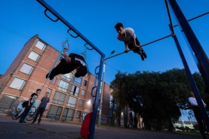 Varias personas usando las maquinas de un gimnasio en un parque