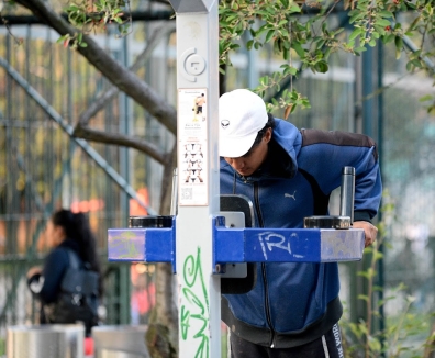 Hombre usando las maquinas de un gimnasio en un parque