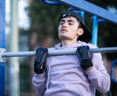 Hombre usando las maquinas de un gimnasio en un parque