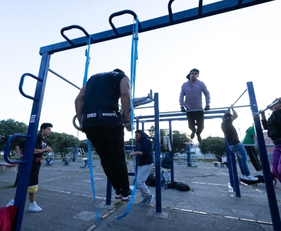 Varias personas usando las maquinas de un gimnasio en un parque