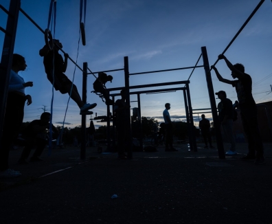 Personas usando las maquinas de un gimnasio en un parque