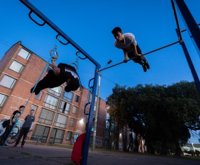 Varias personas usando las maquinas de un gimnasio en un parque
