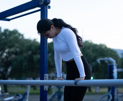 Mujer usando las maquinas de un gimnasio en un parque