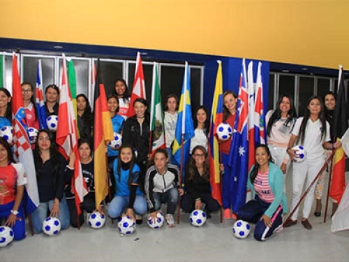 Deportistas sostienen banderas y balones de fútbol