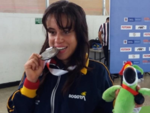Laura Rivera mordiendo medalla