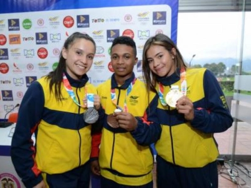 Deportistas mujeres sostienen sus medallas