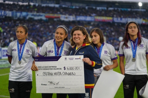 La directora del IDRD Blanca Durán entregando un cheque a una de las jugadoras