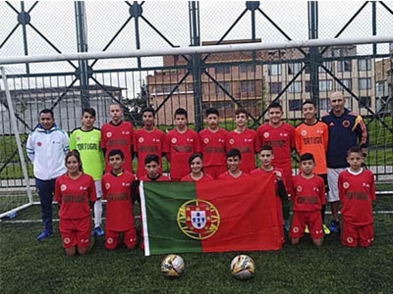 Equipo juvenil de fútbol sostiene bandera