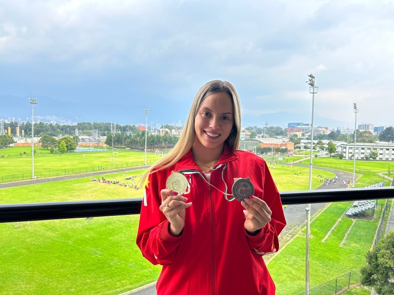 Paula Aguirre mostrando dos medallas