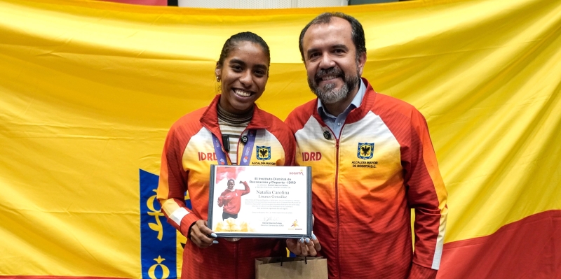 La medallista mundial de salto largo, Natalia Linares, con el director del IDRD, Daniel García Cañón, quien le hizo entrega de una distinción por el logro alcanzado en Tokio 2025. Foto IDRD.