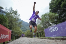 Un hombre saltando con un brazo arriba en el sendero peatonal de Monserrate