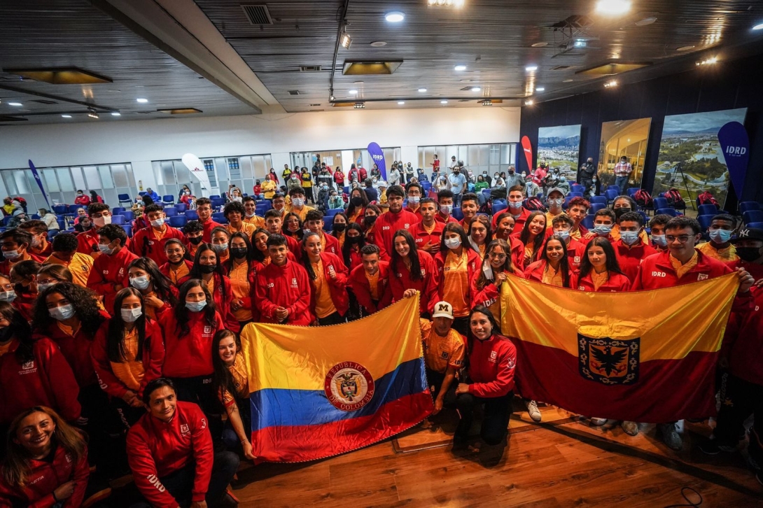 Deportistas del Equipo Bogotá sosteniendo la bandera de Colombia