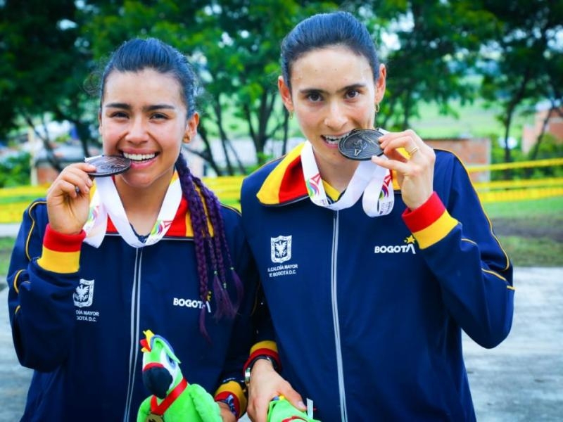 deportistas mordiendo medallas