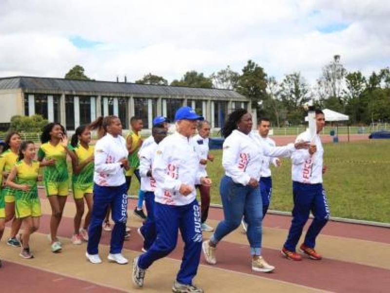 Deportistas corren en pista de atletismo