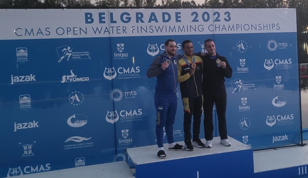 Alexander Jiménez en lo más alto del podio, en el Mundial de Natación con Aletas en aguas abiertas, al lado de Zakharov (izq.) y Armoutsis (der.). Foto cortesía Fedecas.