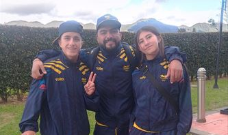 Juan Carlos Polanía (izq.), el entrenador Carlos Mayorga, y Luna Garzón (der.), el equipo de patinaje skateboarding en Los Panamericanos Junior Asunción 2025. Foto IDRD.